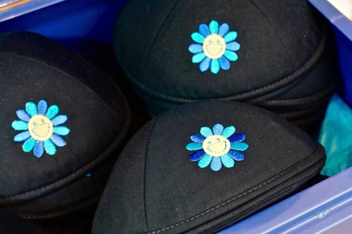 Kippas noires personnalisées avec fleur brodée bleue et turquoise, présentées en coffret.
