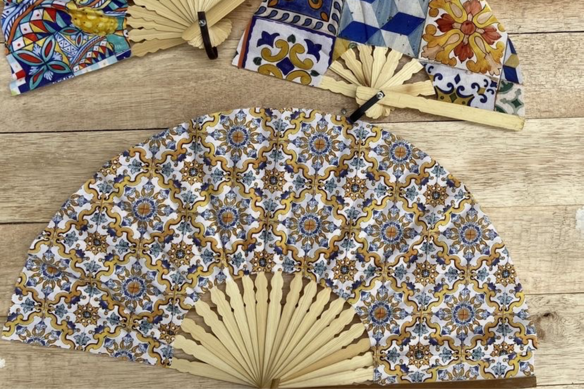 Éventails personnalisés aux motifs de céramiques méditerranéennes colorées avec monture en bois naturel, parfaits pour un mariage ou un événement estival.