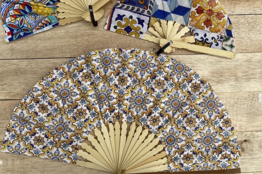 Éventails personnalisés aux motifs de céramiques méditerranéennes colorées avec monture en bois naturel, parfaits pour un mariage ou un événement estival.