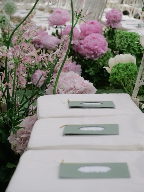 Marque-places de mariage personnalisés intégrés à une décoration florale