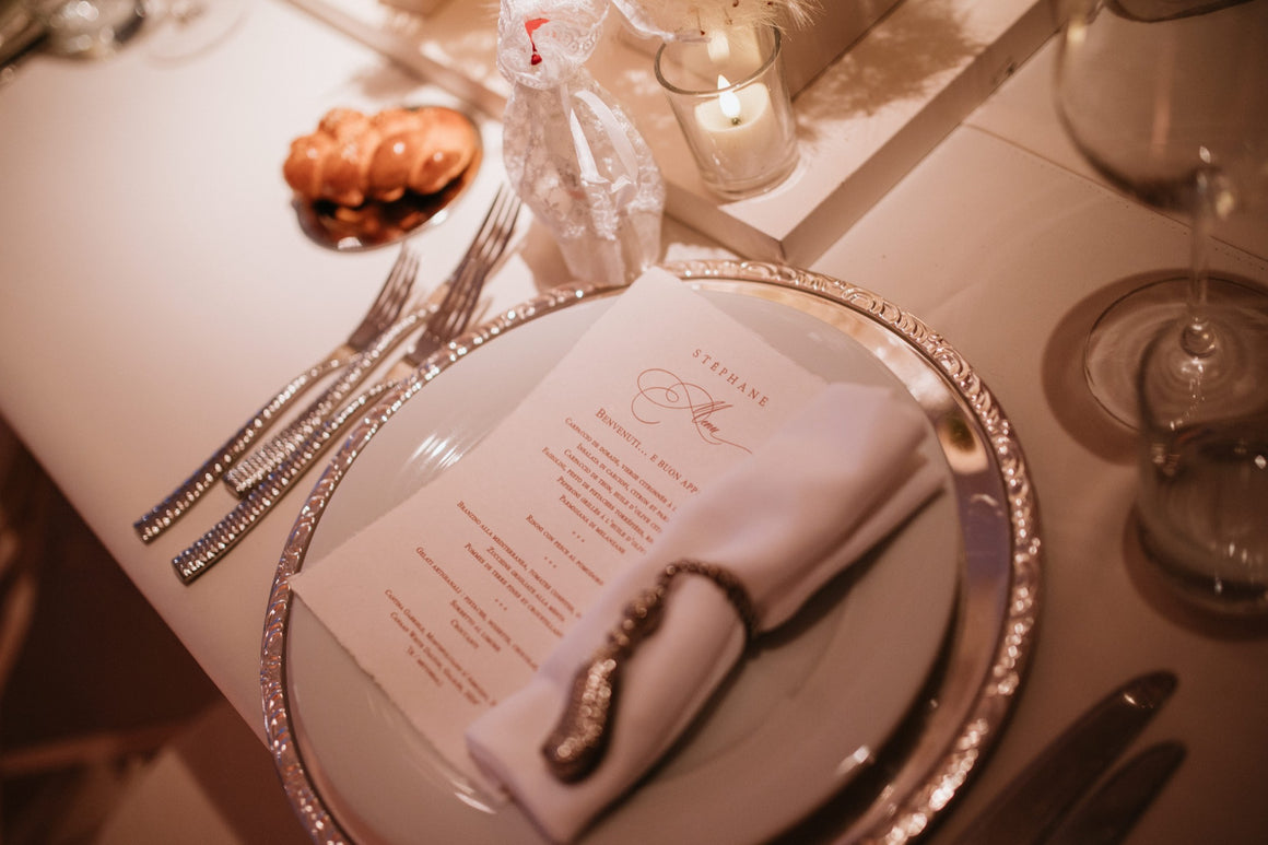 Menu de mariage personnalisé posé sur une assiette avec serviette élégante