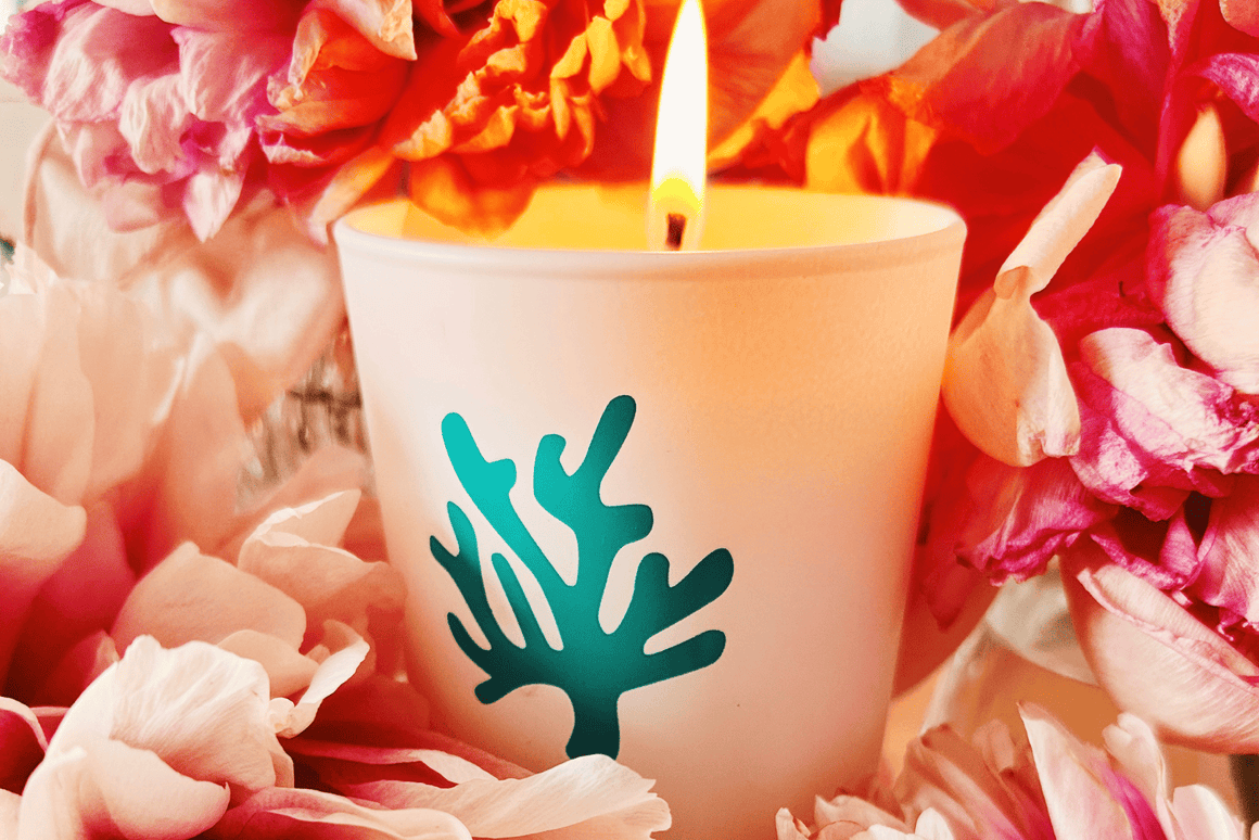 Bougie parfumée personnalisée présentée au milieu de fleurs roses, idéale comme cadeau invité pour mariage, Bar Mitsvah, Bat Mitsvah ou événement haut de gamme.
