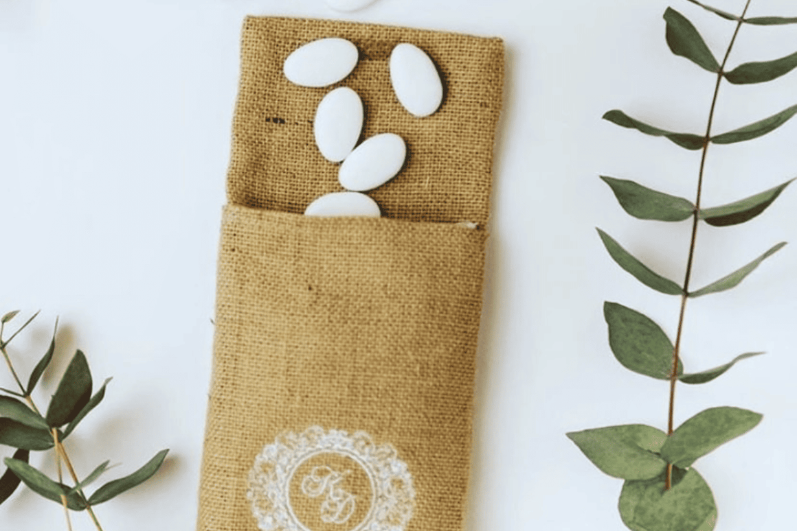 Pochon à dragées personnalisé en toile de jute avec monogramme brodé blanc, rempli de dragées, idéal pour un mariage, une Bar Mitsvah, un baptême ou un événement élégant.